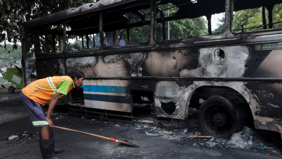 A man looks at a damaged bus of Sri Lanka's ruling party supporters after it was set on fire during a clash of pro and anti-government demonstrators near the Prime Minister's official residence. (Photo: Reuters) A man looks at a damaged bus of Sri Lanka's ruling party supporters after it was set on fire during a clash of pro and anti-government demonstrators near the Prime Minister's official residence. (Photo: Reuters)
