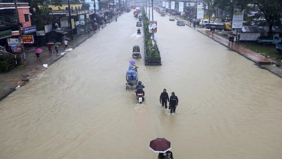 People wade through flooded waters in Sylhet, Bangladesh. People wade through flooded waters in Sylhet, Bangladesh.