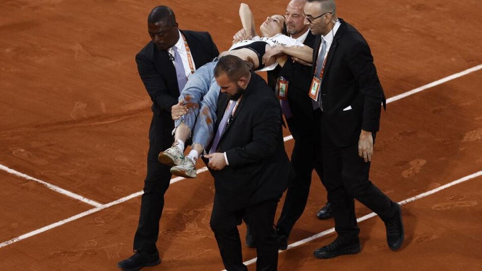 Security members take off the court a protestor after she ties herself to the net during the French Open semi final (Photo: Reuters) Security members take off the court a protestor after she ties herself to the net during the French Open semi final (Photo: Reuters)
