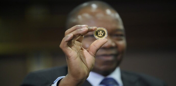 Reserve Bank of Zimbabwe Governor, John Mangudya holds a sample of a gold coin. Reserve Bank of Zimbabwe Governor, John Mangudya holds a sample of a gold coin.