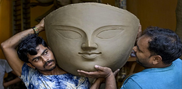 Workers carry the face of a clay model of Goddess Durga at a workshop to prepare idols ahead of Durga Puja festival Workers carry the face of a clay model of Goddess Durga at a workshop to prepare idols ahead of Durga Puja festival