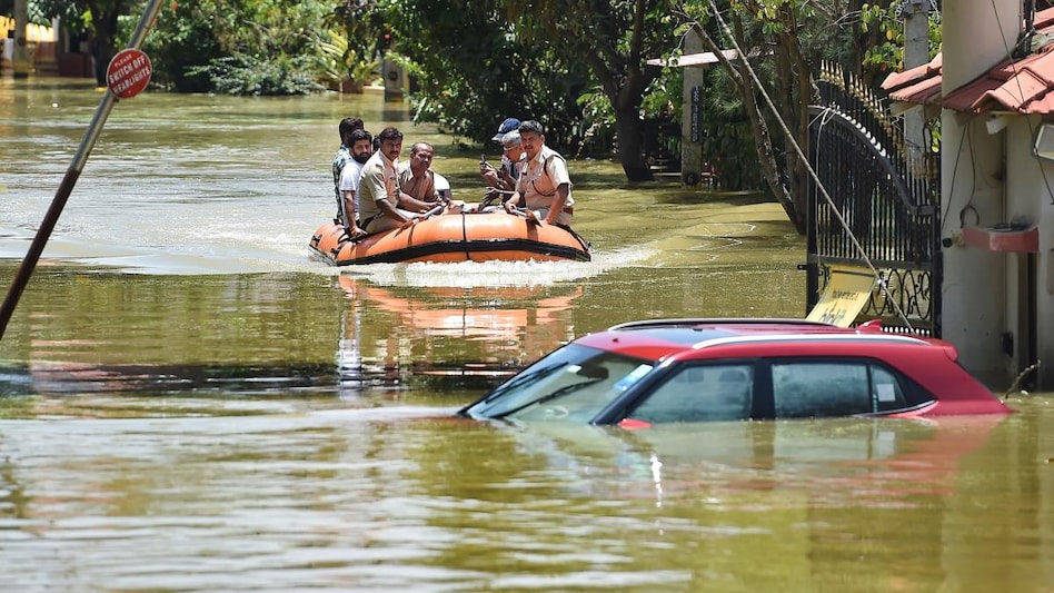 Fire fighters while evacuating residents from flooded Rainbow Drive Layout locality after heavy monsoon rains in Bengaluru. Fire fighters while evacuating residents from flooded Rainbow Drive Layout locality after heavy monsoon rains in Bengaluru.