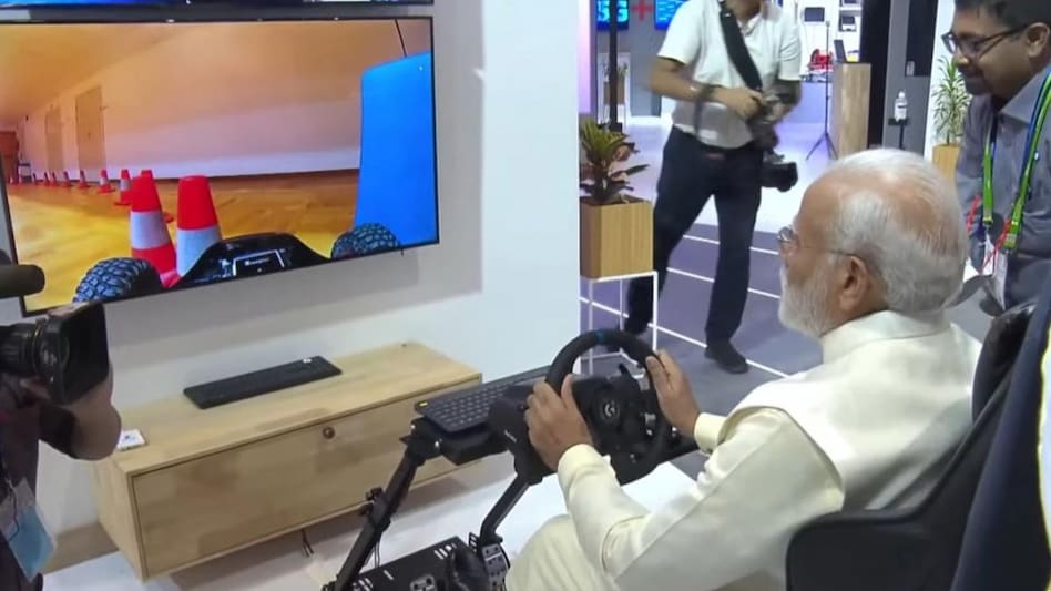At the Swedish telecommunication giant’s stall, the vehicle was set up to navigate a closed indoor course in Europe and PM Modi managed the vehicle via controls. At the Swedish telecommunication giant’s stall, the vehicle was set up to navigate a closed indoor course in Europe and PM Modi managed the vehicle via controls.
