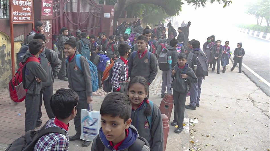 Students wait outside their school on a road engulfed in smog in New Delhi Students wait outside their school on a road engulfed in smog in New Delhi