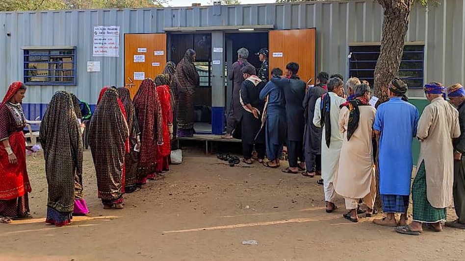 Voters wait in queues to cast their votes at a polling station made from shipping container during the first phase of Gujarat Assembly elections Voters wait in queues to cast their votes at a polling station made from shipping container during the first phase of Gujarat Assembly elections