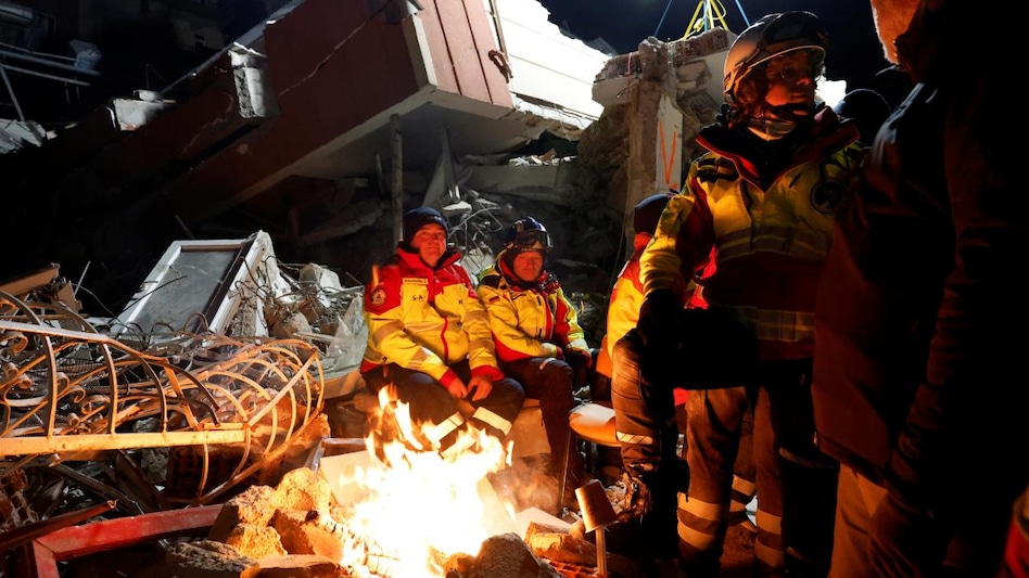 Members of the ISAR Germany rescue team keep warm by a fire, as the search for survivors continues, in the aftermath of a deadly earthquake Members of the ISAR Germany rescue team keep warm by a fire, as the search for survivors continues, in the aftermath of a deadly earthquake