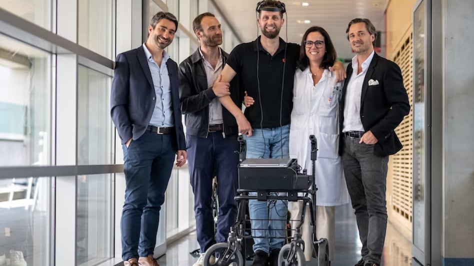Gert-Jan Oskam, centre, stands with researchers who helped him regain the ability to walk using only his thoughts. (AFP: Fabrice Coffrini) Gert-Jan Oskam, centre, stands with researchers who helped him regain the ability to walk using only his thoughts. (AFP: Fabrice Coffrini)