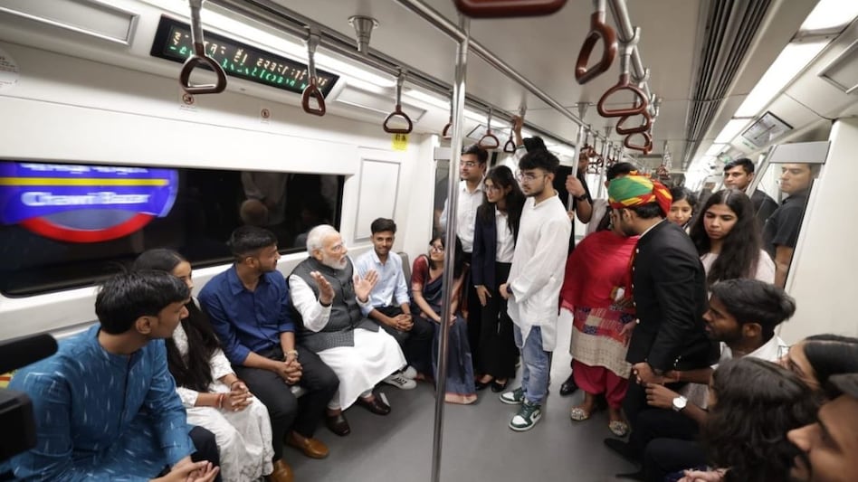 PM Modi interacted with commuters after boarding the yellow line metro train on Friday. PM Modi interacted with commuters after boarding the yellow line metro train on Friday.