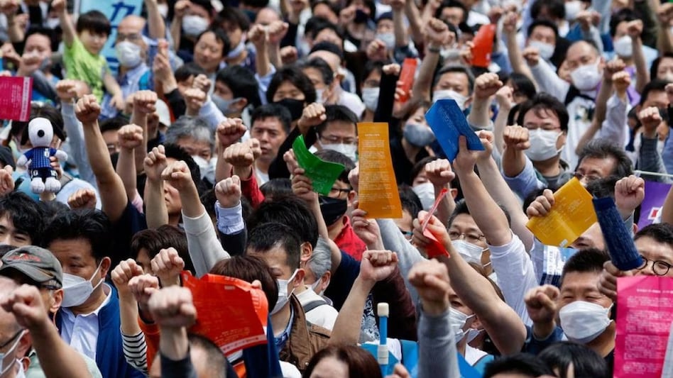 Members of the Japanese Trade Union Confederation, commonly known as Rengo, raise their fists as they shout Gambaro and cheer during their annual May Day rally to demand higher pay and better working conditions, in Tokyo, Japan Members of the Japanese Trade Union Confederation, commonly known as Rengo, raise their fists as they shout Gambaro and cheer during their annual May Day rally to demand higher pay and better working conditions, in Tokyo, Japan
