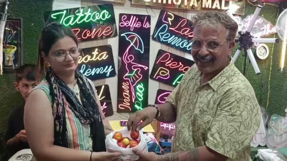 Muft! Muft! Muft!: Tattoo shop owner in Varanasi shocks customers, gives one kilo tomatoes free in return for a tattoo The owner of the tattoo shop in Varanasi posing with one of his customers