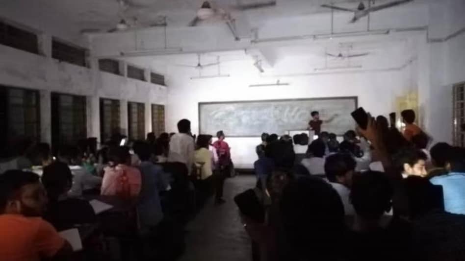 Amidst a power outage, the determined students used their flashlights to continue learning. Amidst a power outage, the determined students used their flashlights to continue learning.