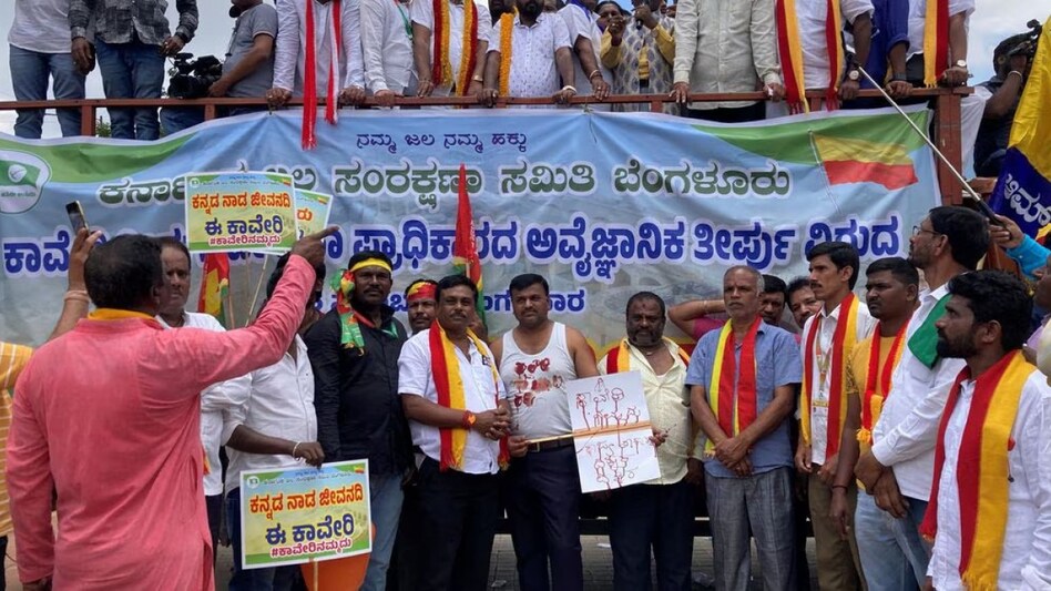 Demonstrators hold placards next to a banner as they attend a protest against the sharing of Cauvery river water with neighbouring Tamil Nadu state Demonstrators hold placards next to a banner as they attend a protest against the sharing of Cauvery river water with neighbouring Tamil Nadu state