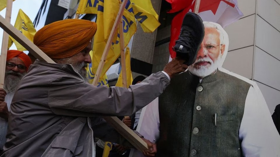 About 100 protesters in Toronto burned an Indian flag and struck a cardboard cut-out of Indian Prime Minister Narendra Modi with a shoe About 100 protesters in Toronto burned an Indian flag and struck a cardboard cut-out of Indian Prime Minister Narendra Modi with a shoe