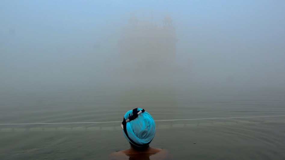 Amritsar: A devotee takes a dip in the 'holy sarovar' at the Golden Temple amid dense fog, in Amritsar, Monday Amritsar: A devotee takes a dip in the 'holy sarovar' at the Golden Temple amid dense fog, in Amritsar, Monday