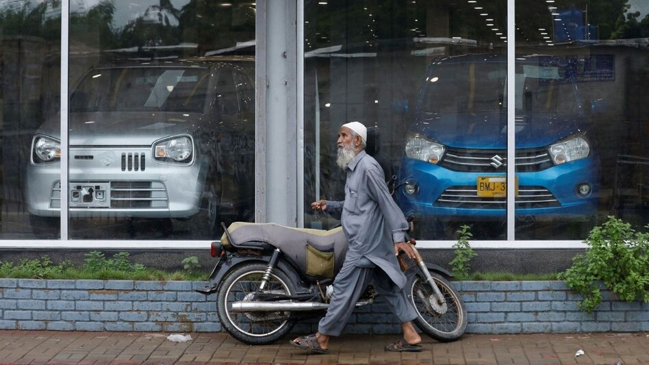 A man walks past a Suzuki outlet, displaying cars in Karachi, Pakistan, July 27, 2022. REUTERS/Akhtar Soomro A man walks past a Suzuki outlet, displaying cars in Karachi, Pakistan, July 27, 2022. REUTERS/Akhtar Soomro