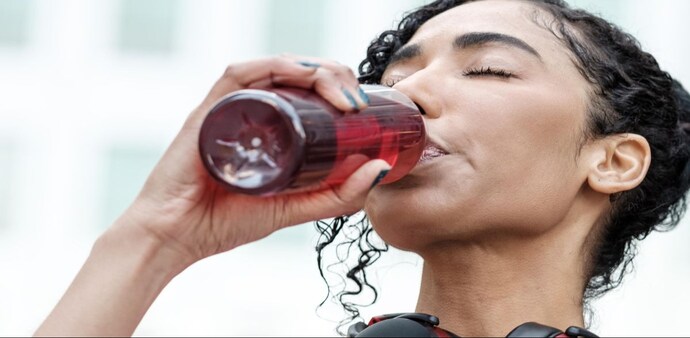 A woman having an energy drink A woman having an energy drink