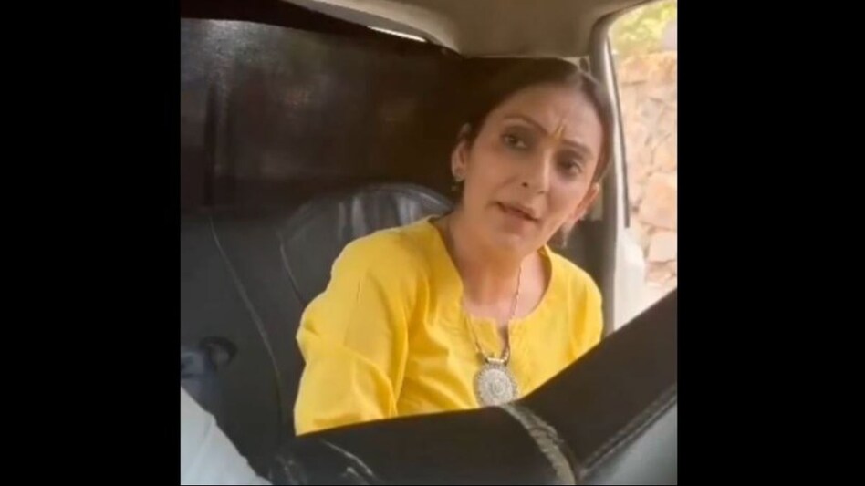 The short clip, filmed by a bystander, shows the woman yelling profanities at the driver. The short clip, filmed by a bystander, shows the woman yelling profanities at the driver.