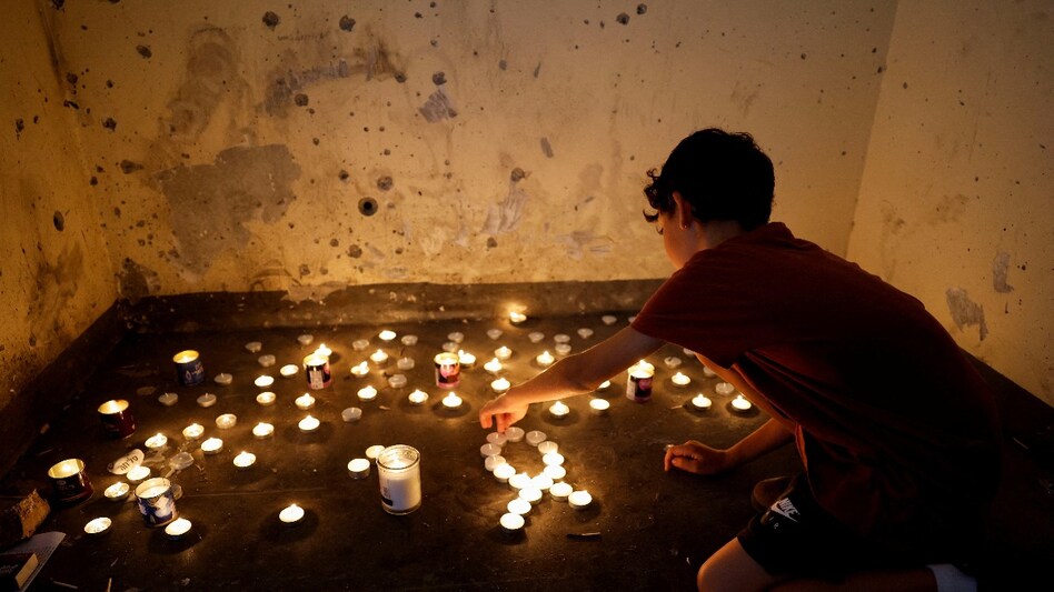 A boy lights candles inside a bomb shelter where people were killed during the deadly October 7 attack by Hamas, on the first anniversary since the attack, near Kibbutz Mefalsim in southern Israel. A boy lights candles inside a bomb shelter where people were killed during the deadly October 7 attack by Hamas, on the first anniversary since the attack, near Kibbutz Mefalsim in southern Israel.