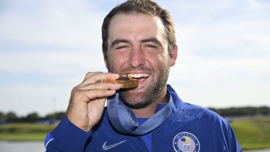 World number one Scottie Scheffler who will appear in “The Showdown” exhibition alongside world no. 3 Rory McIlroy against LIV Golf stars Bryson DeChambeau and Brooke Koepka with his Olympic gold medal in Paris. Image courtesy Olympic Golf. World number one Scottie Scheffler who will appear in “The Showdown” exhibition alongside world no. 3 Rory McIlroy against LIV Golf stars Bryson DeChambeau and Brooke Koepka with his Olympic gold medal in Paris. Image courtesy Olympic Golf.