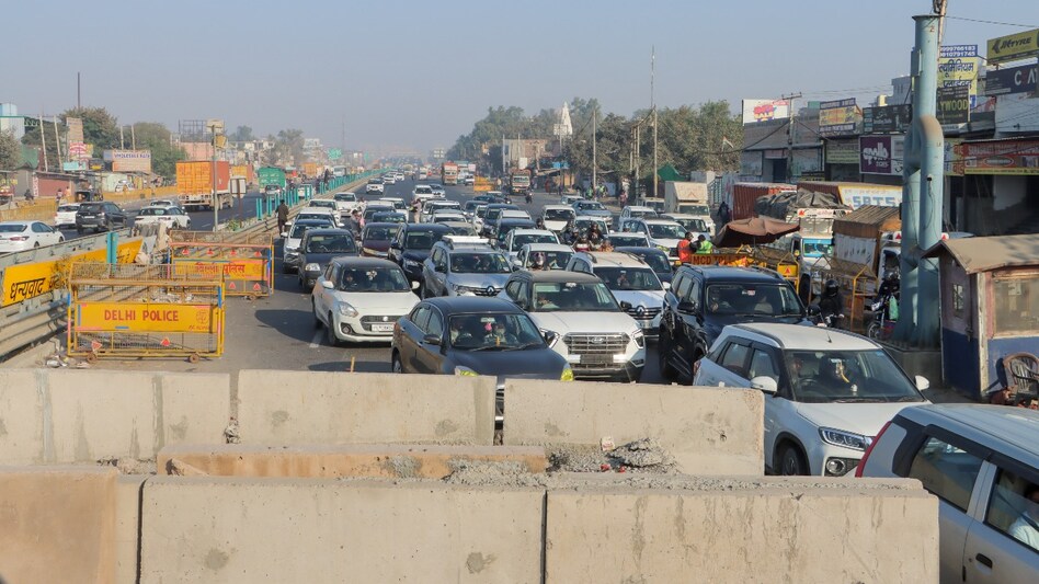 Security personnel behind cement barricades with iron grills instructed the farmers not to move forward, as they lacked permission. Security personnel behind cement barricades with iron grills instructed the farmers not to move forward, as they lacked permission.