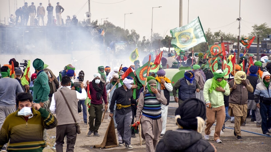 Farmers run for cover after police used teargas to disperse them during their protest at the Shambhu border, in Patiala district, on December 8. Farmers run for cover after police used teargas to disperse them during their protest at the Shambhu border, in Patiala district, on December 8.