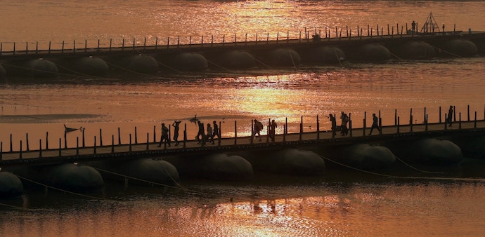 People walk along the pontoon bridge over Ganga, that has been newly constructed for the Maha Kumbh Mela 2025 in Prayagraj on December 16. People walk along the pontoon bridge over Ganga, that has been newly constructed for the Maha Kumbh Mela 2025 in Prayagraj on December 16.