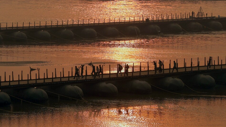 People walk along the pontoon bridge over Ganga, that has been newly constructed for the Maha Kumbh Mela 2025 in Prayagraj on December 16. People walk along the pontoon bridge over Ganga, that has been newly constructed for the Maha Kumbh Mela 2025 in Prayagraj on December 16.