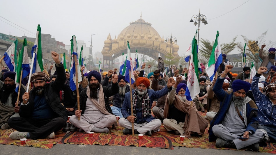 Farmers raise slogans as they block a road during the statewide 'bandh' called as part their ongoing protest, near Golden Gate, in Amritsar, on December 30. Farmers raise slogans as they block a road during the statewide 'bandh' called as part their ongoing protest, near Golden Gate, in Amritsar, on December 30.