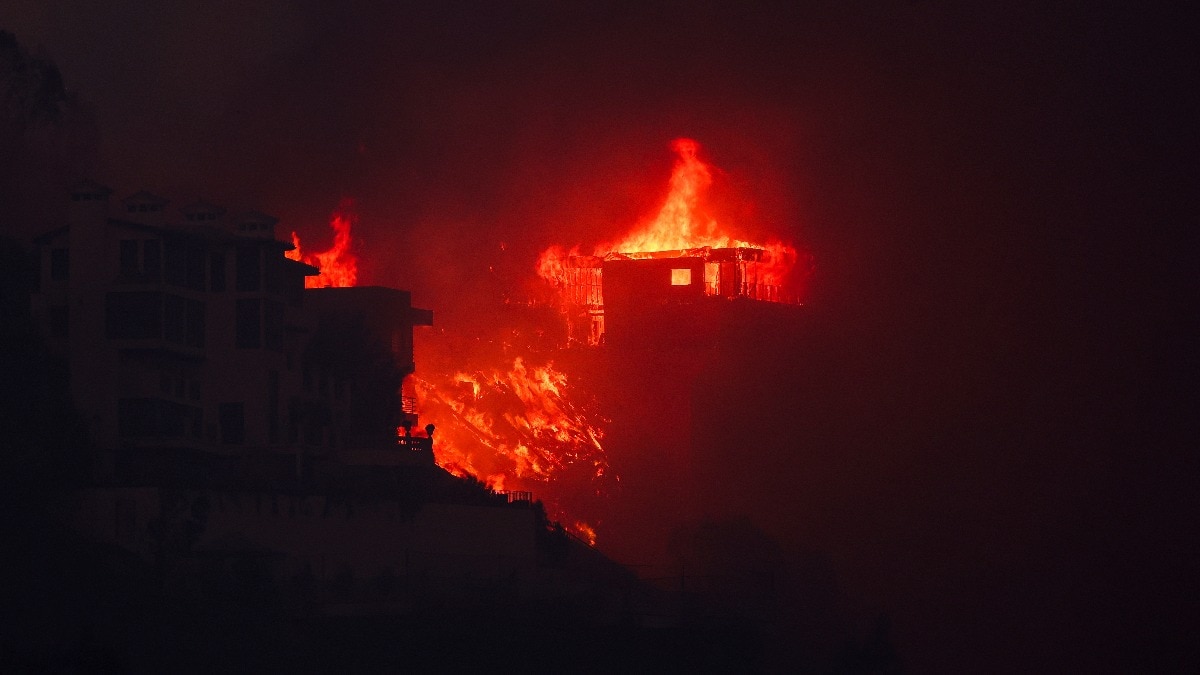 Flames rise from beachfront homes along the road to Malibu, as powerful winds fueling devastating wildfires in the Los Angeles area force people to evacuate