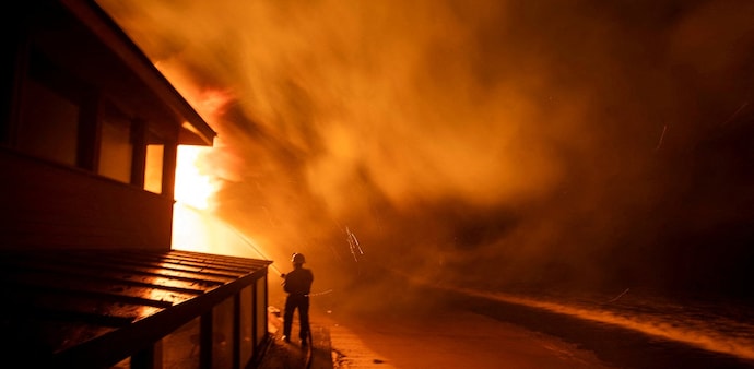 A firefighter battles the Palisades fire as it burns during a windstorm on the west side of Los Angeles, California. A firefighter battles the Palisades fire as it burns during a windstorm on the west side of Los Angeles, California.