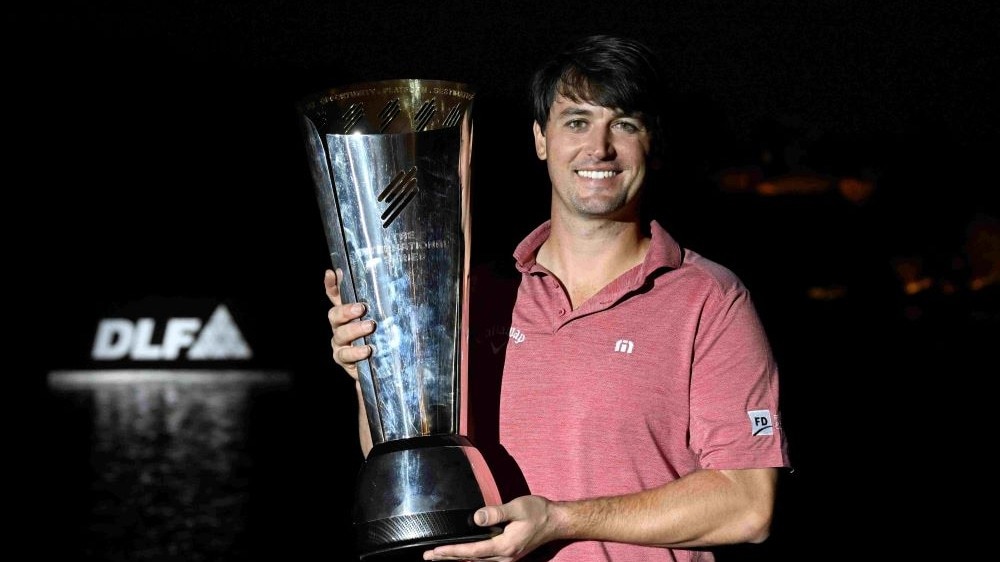 Ollie Schniederjans with his International Series India presented by DLF trophy in Gurgaon on Sunday. Image courtesy Asian Tour. Ollie Schniederjans with his International Series India presented by DLF trophy in Gurgaon on Sunday. Image courtesy Asian Tour.