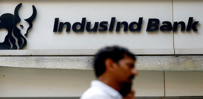 A man walks outside a branch of IndusInd Bank A man walks outside a branch of IndusInd Bank