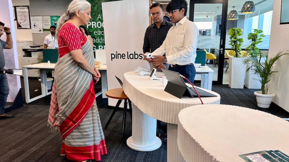 FM Nirmala Sitharaman engages with a Pine Labs staff member. Photo credit: X account of FM Sitharaman. FM Nirmala Sitharaman engages with a Pine Labs staff member. Photo credit: X account of FM Sitharaman.