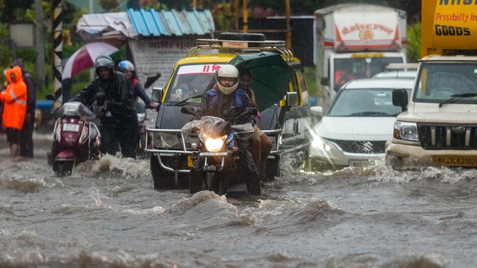 Mumbai rains: Commuters wade through a waterlogged road at Dadar Mumbai rains: Commuters wade through a waterlogged road at Dadar