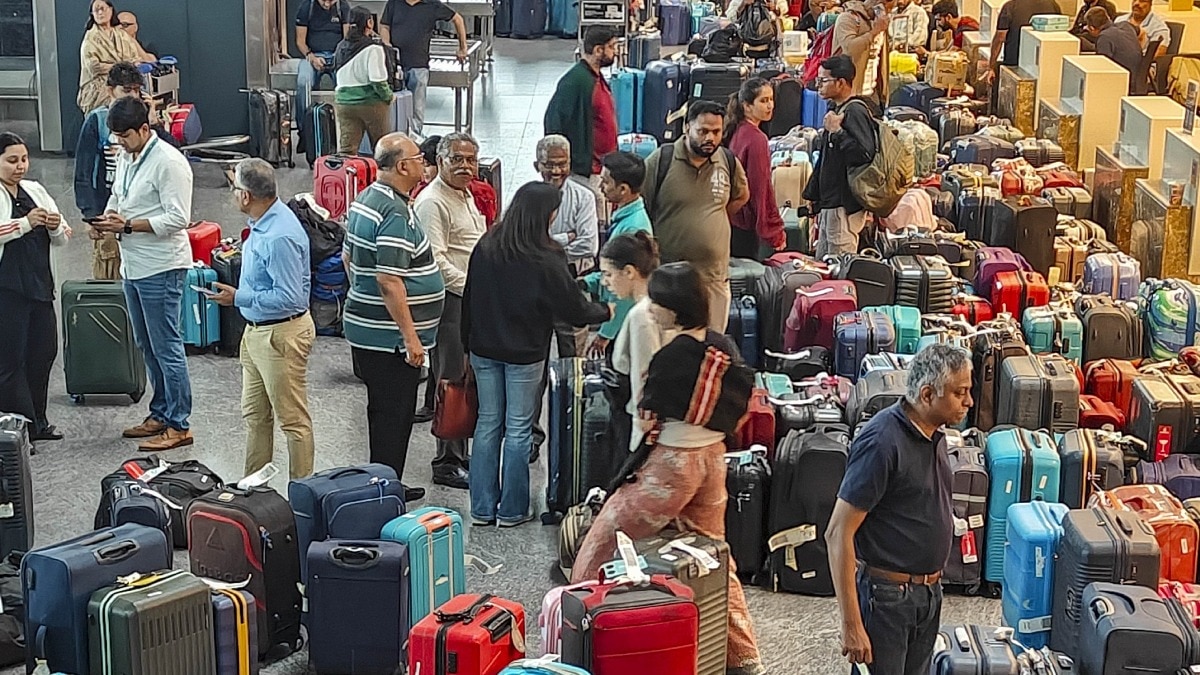 Stranded passengers searching for their luggage near a counter at the Kempegowda International Airport after IndiGo cancelled several flights.