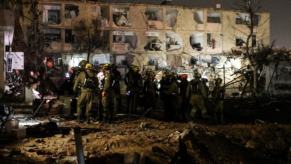 Israeli soldiers work at the scene of damage after Iranian missile barrages struck Dimona. (Reuters photo) Israeli soldiers work at the scene of damage after Iranian missile barrages struck Dimona. (Reuters photo)