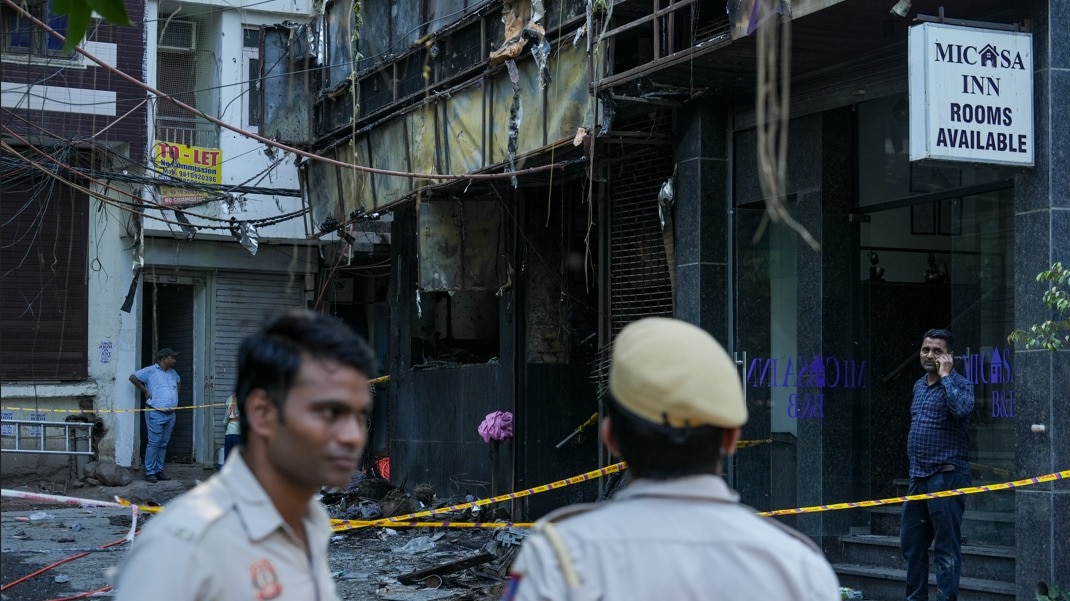 Delhi hotel fire: Police personnel stand guard near the site of a fire at a hotel in the Malviya Nagar area
