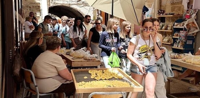 Fresh pasta dries outside doorways while neighbours move freely between homes, creating a scene that feels more like a family courtyard than a tourist attraction. Fresh pasta dries outside doorways while neighbours move freely between homes, creating a scene that feels more like a family courtyard than a tourist attraction.