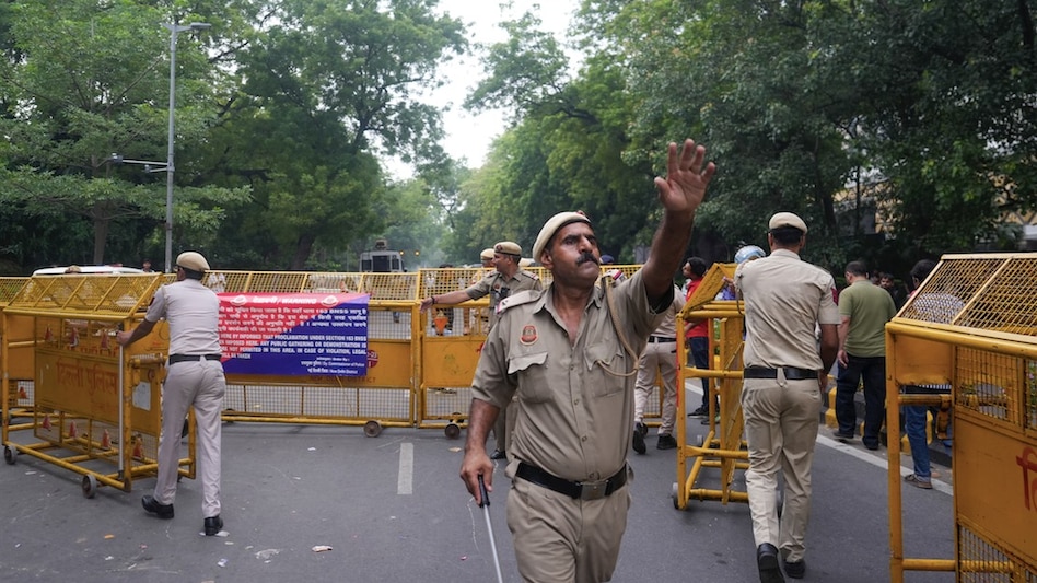 Police personnel block a road with barricades, ahead of the Cockroach Janata Party's protest march Police personnel block a road with barricades, ahead of the Cockroach Janata Party's protest march