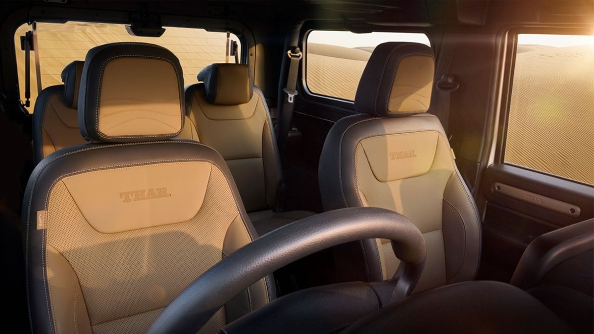 The interiors feature a black base with light beige accents and beige leatherette seats with dune designs on the headrests.
