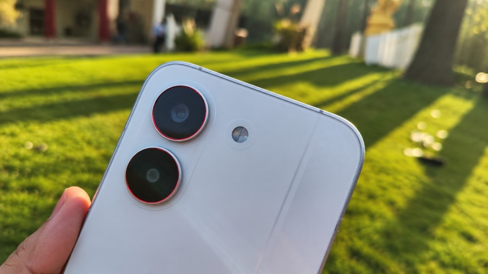 Redmi Turbo 5’s white rear panel features dual cameras with red accent rings.