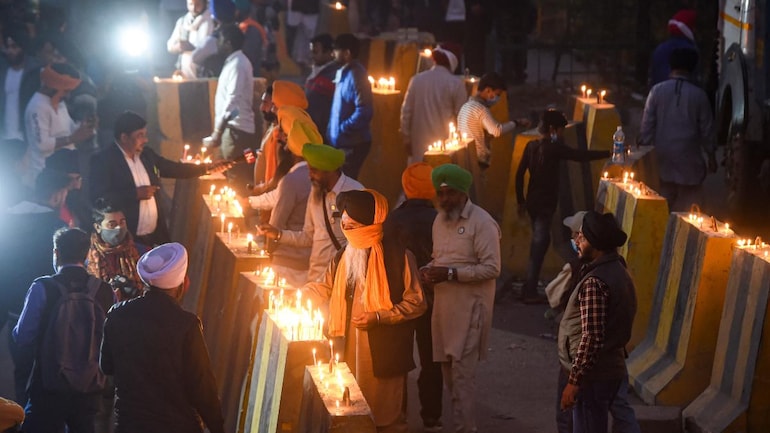 Protesting farmers light candles at Singhu border on the occasion of Guru Nanak Dev's birth anniversary on Monday