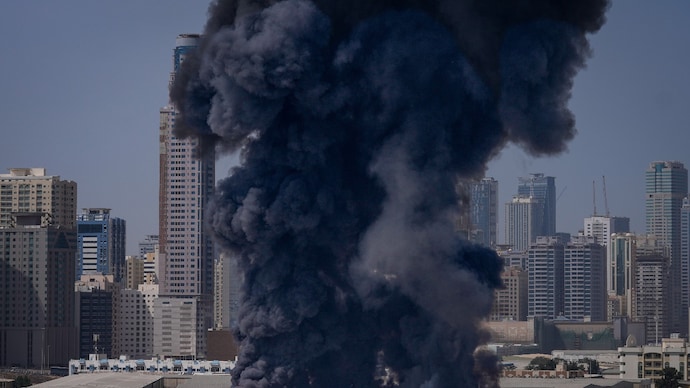 Image shows black plume of smoke rises from a warehouse in Sharjah City in the UAE after Iranian strokes. (AP photo)
