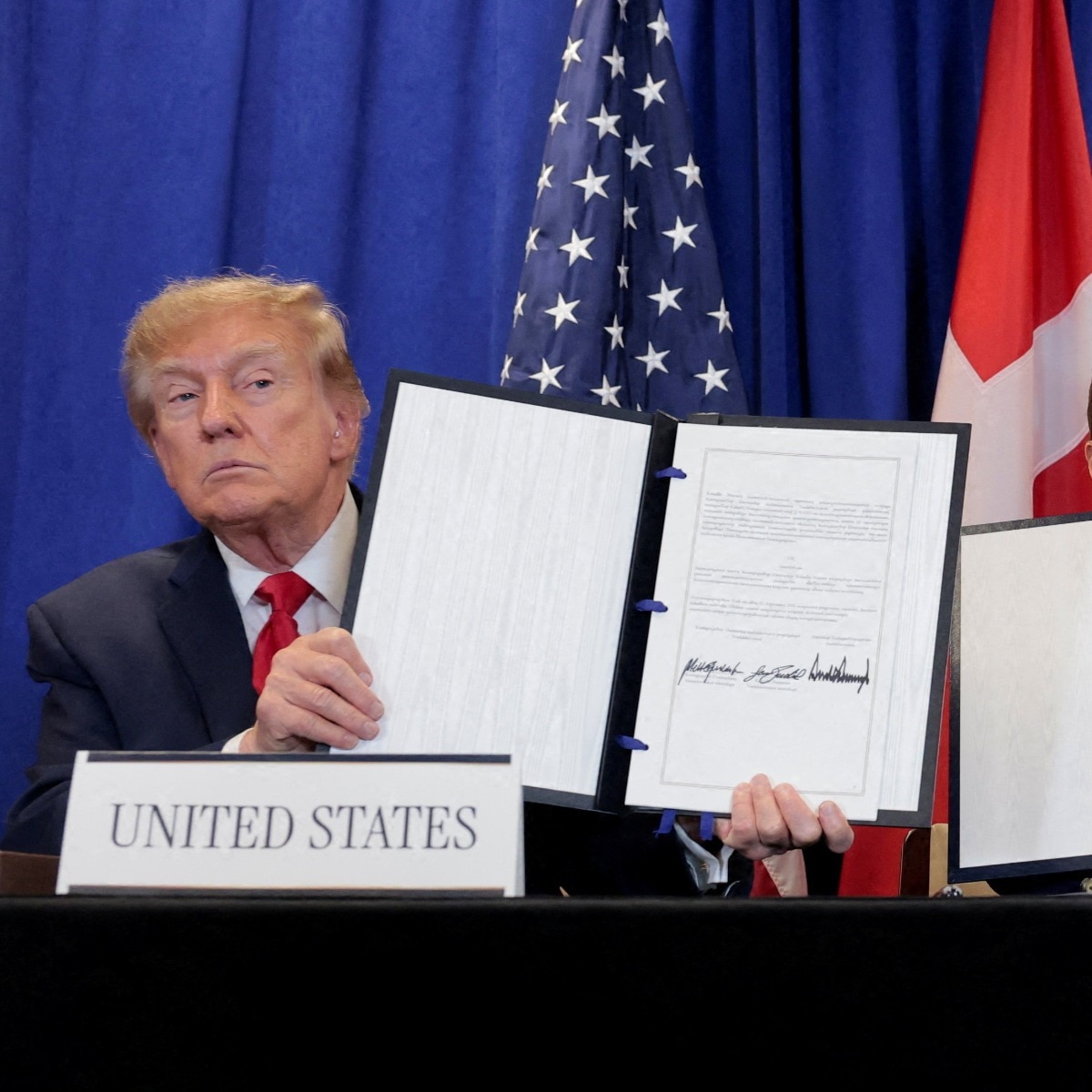 US President Donald Trump, Danish Prime Minister Mette Frederiksen and Greenland Prime Minister Jens-Frederik Nielsen show signed documents.