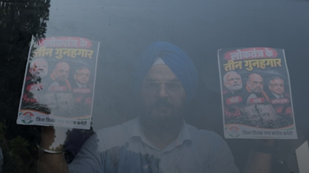 Detained protester holds up placards through bus window