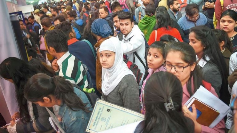 Aspirants stand in queues during a job fair in New Delhi.