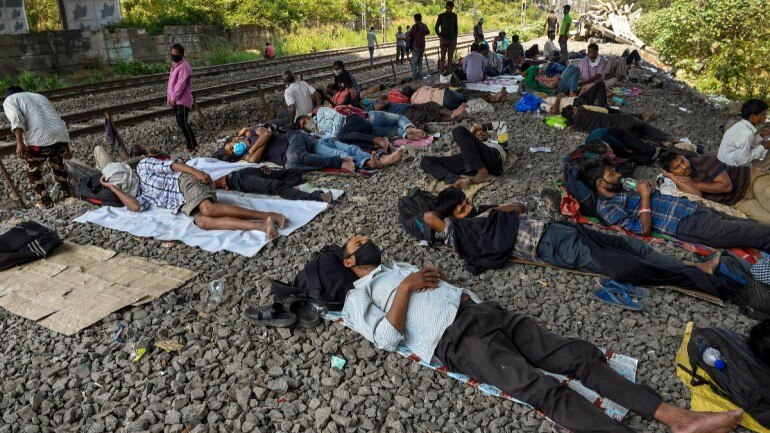 Migrant workers stranded in Mumbai sleep under a railway bridge