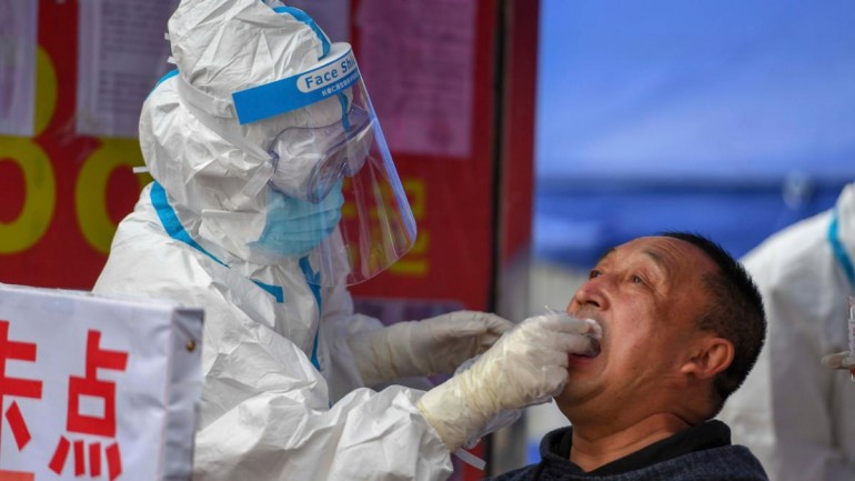 A healthcare worker collects a swab for testing in China's Jilin province on May 18