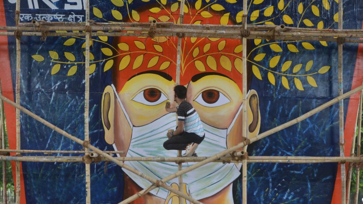 In Noida, an artist draws a mural on the pillar of elevated road to spread awareness about Covid-19. (Photo by K. Asif/Mail Today)