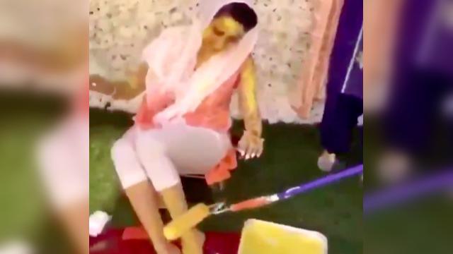 Woman applies turmeric on bride with paint roller